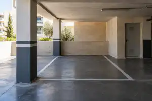 מקום חניה מסומן ודלת מחסן בקומת חניה של בניין