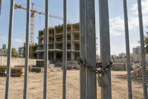 אתר בנייה לא גמור מאחורי שער סגור
