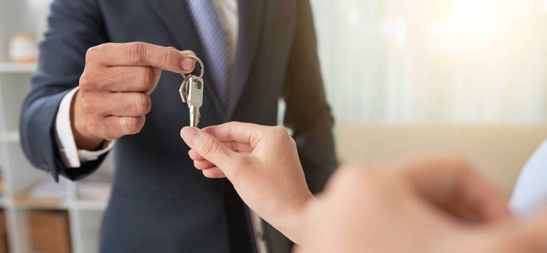 Hand of woman taking keys from hand of real estate owner